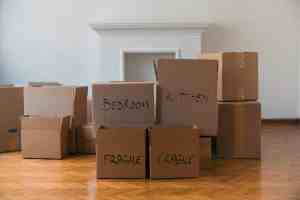 Stacked cardboard boxes labeled with 'Bedroom,' 'Kitchen,' and 'Fragile,' ready for moving day